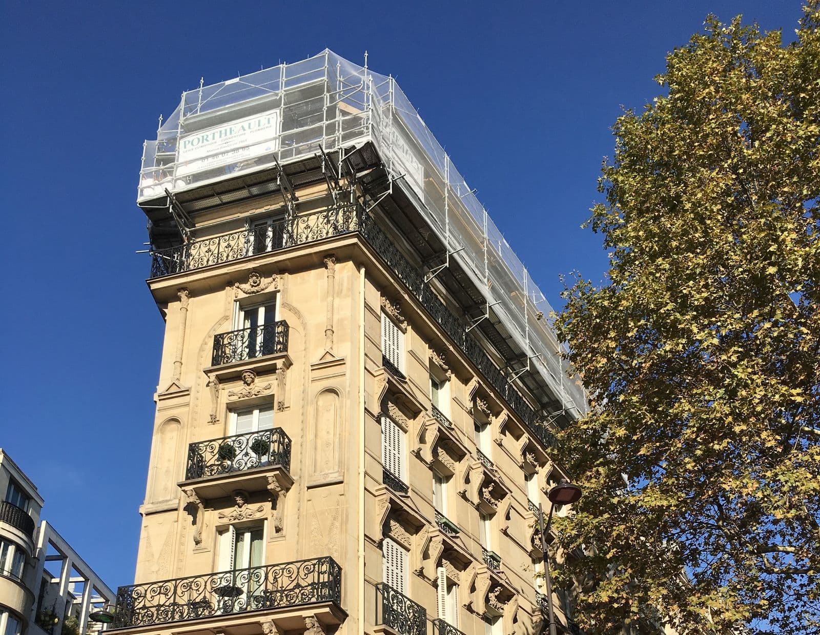 Immeuble parisien sous échafaudage pendant des travaux de couverture Portheault