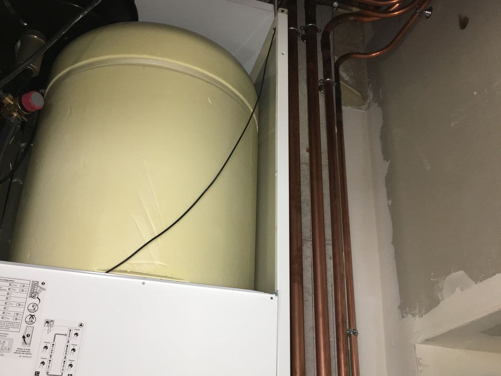 Ballon d'eau chaude et colonnes de cuivre dans un local technique